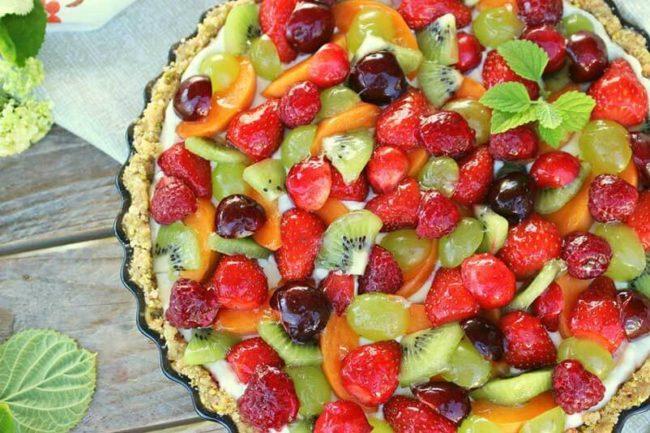 Decora el pastís de xocolata amb baies i fruites.